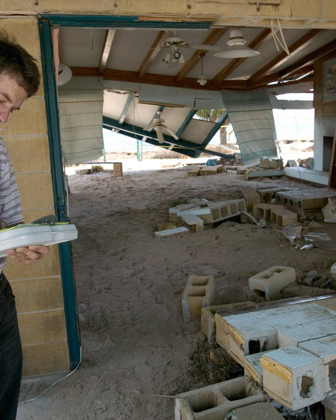 Insurance adjuster documenting a wrecked ground floor