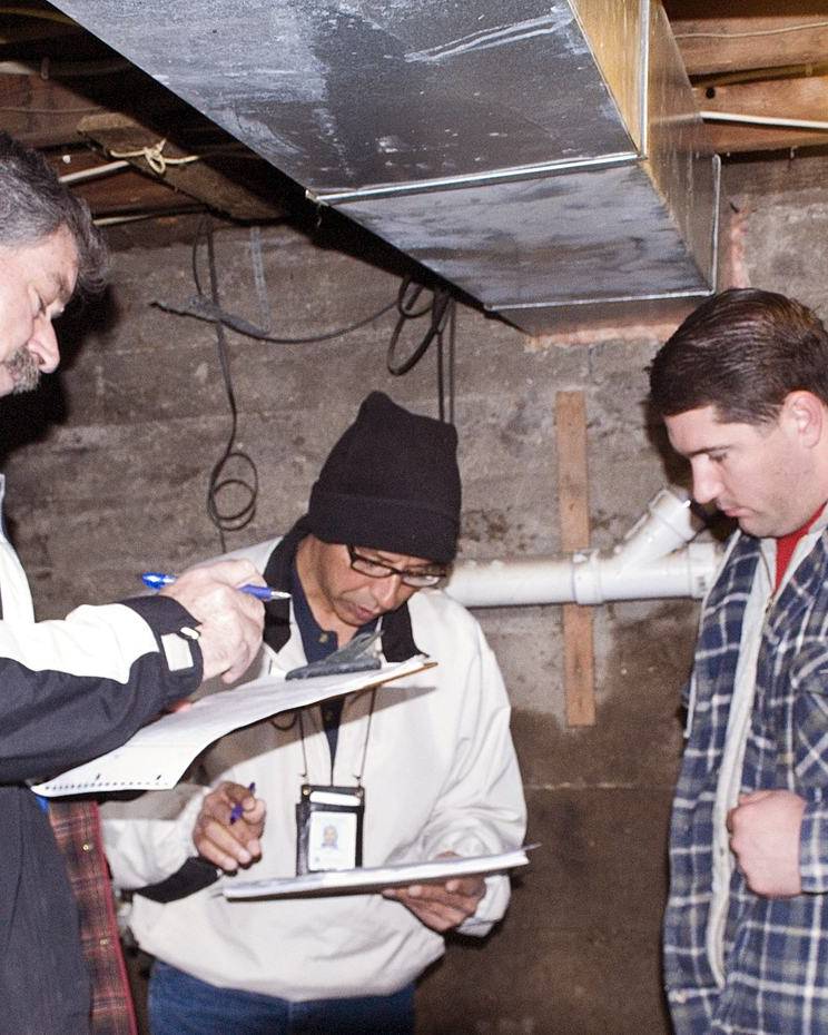 Assessors going over paperwork with a homeowner in his flooded basement