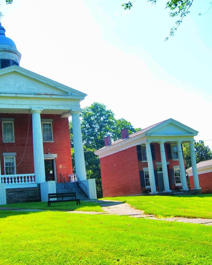 Brick county courthouse with white columns and a cupola