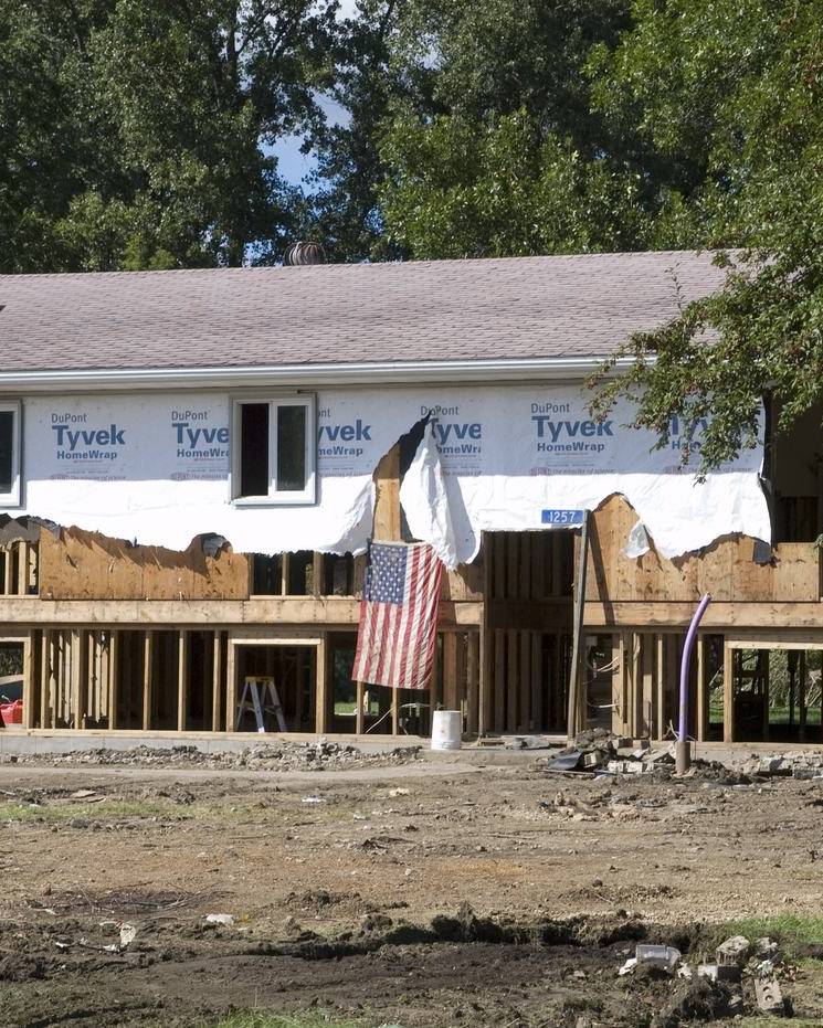 Flood-damaged house stripped back to its framing and house wrap