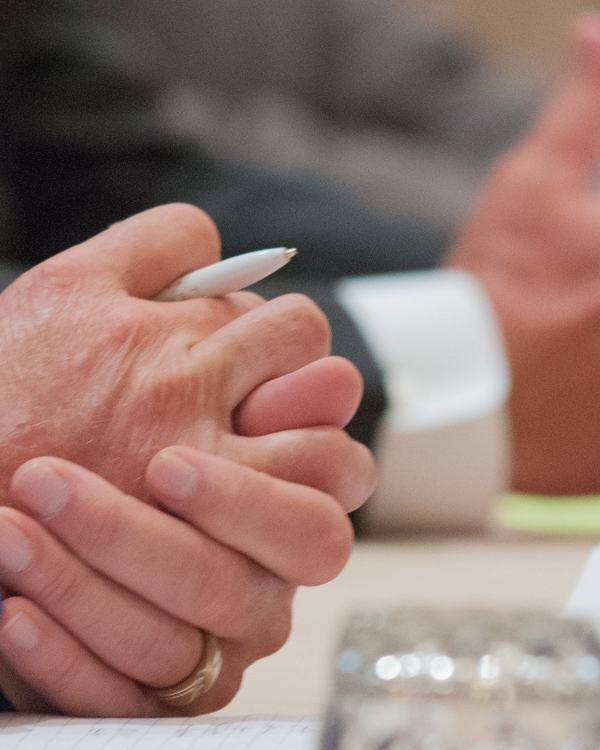 Hands of two people in discussion across a meeting table