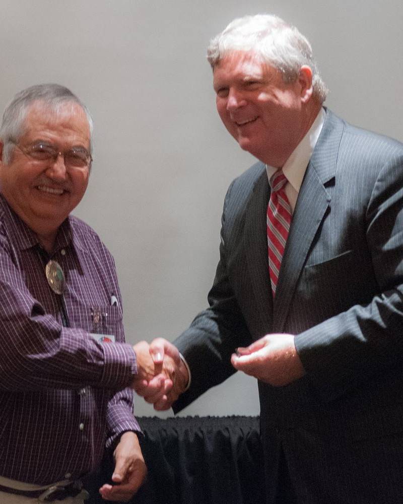 Two men shaking hands at a meeting