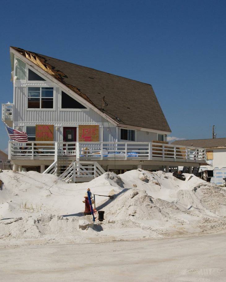 Hurricane-damaged homes and drifted sand on Pensacola Beach, Florida