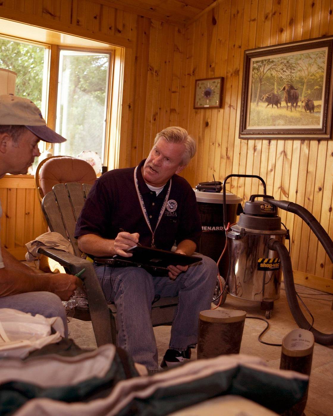 Damage inspector interviewing a homeowner in his living room