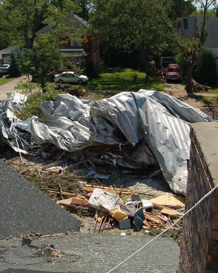 Metal roofing torn off and dumped across a yard by a tornado