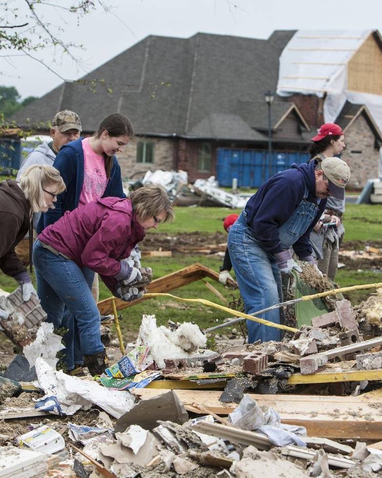 Volunteers clearing storm debris from a damaged home