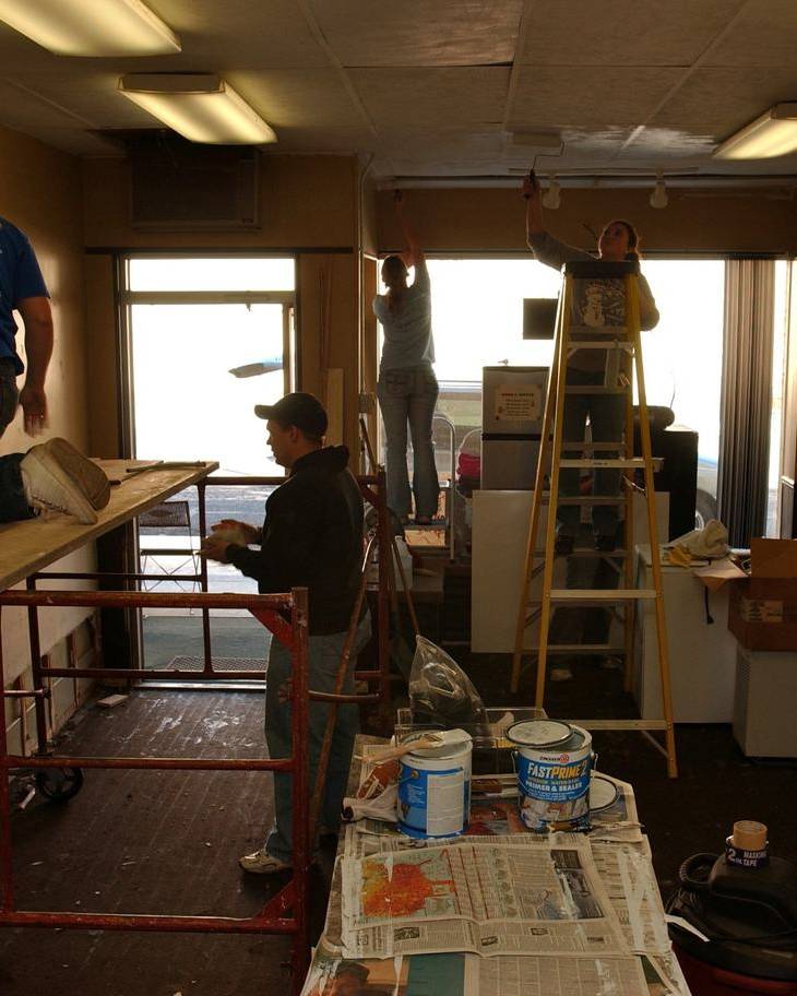 Volunteers repairing the gutted interior of a flood-damaged cafe