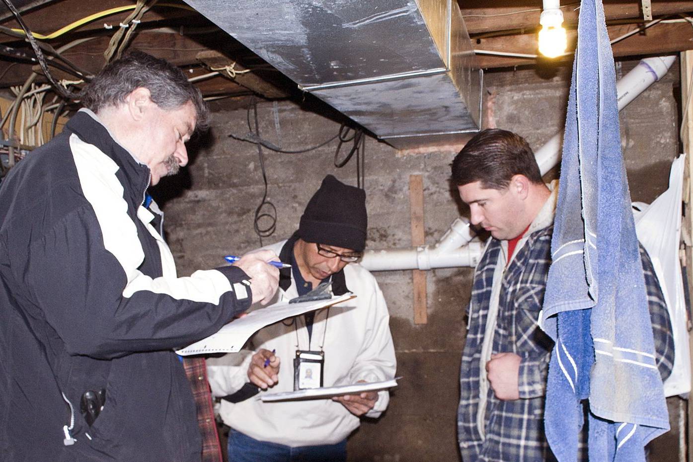 Assessors going over paperwork with a homeowner in his flooded basement
