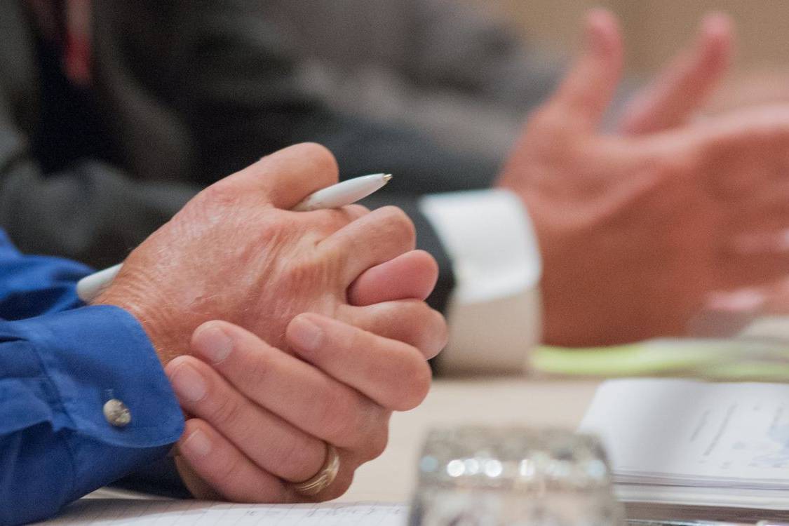 Hands of two people in discussion across a meeting table
