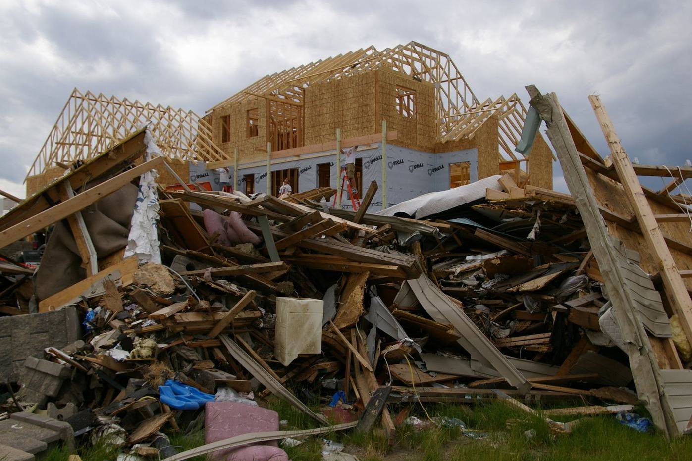 House being rebuilt after a tornado, with new framing and debris still on the ground
