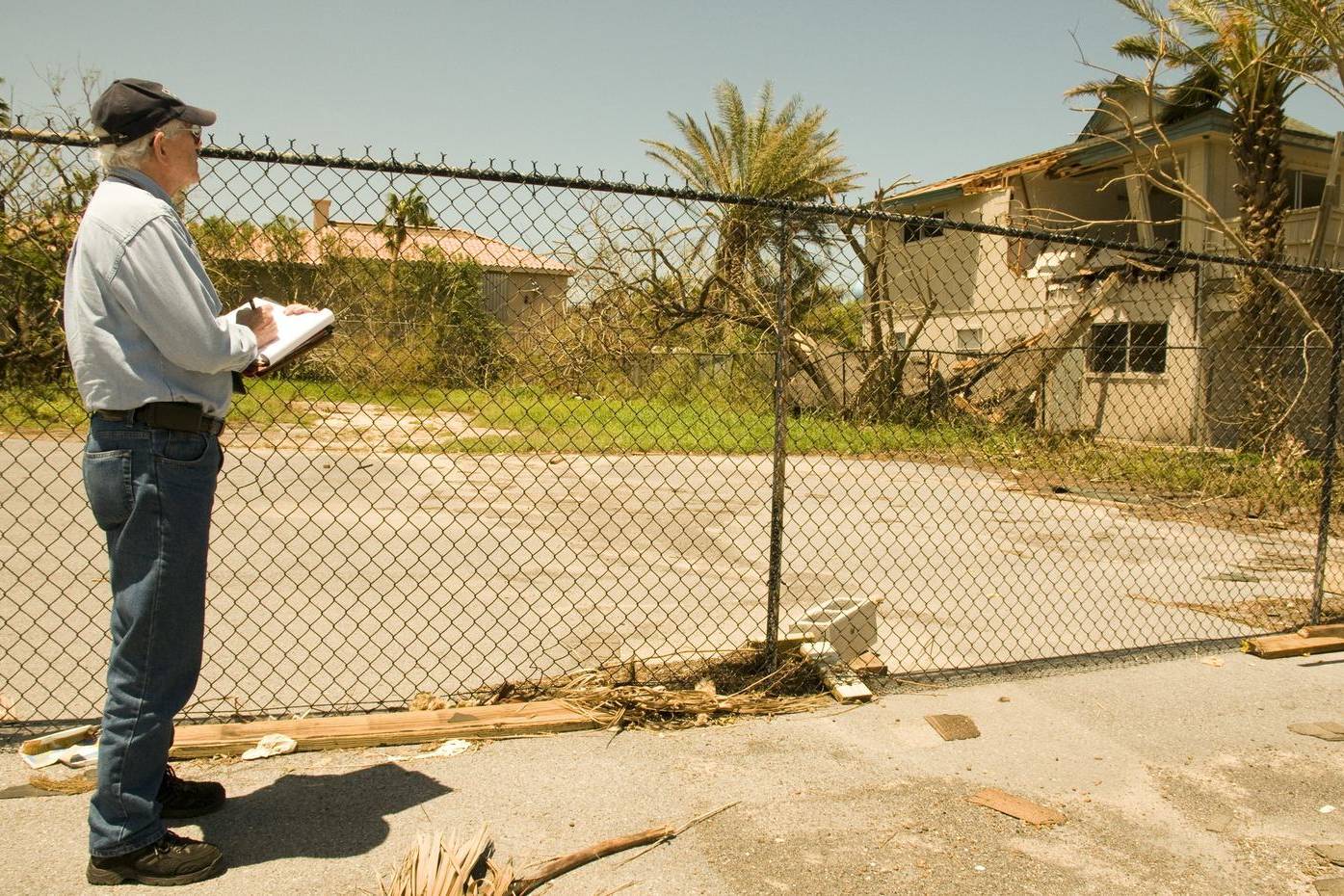 Inspector with a clipboard at a storm-damaged property
