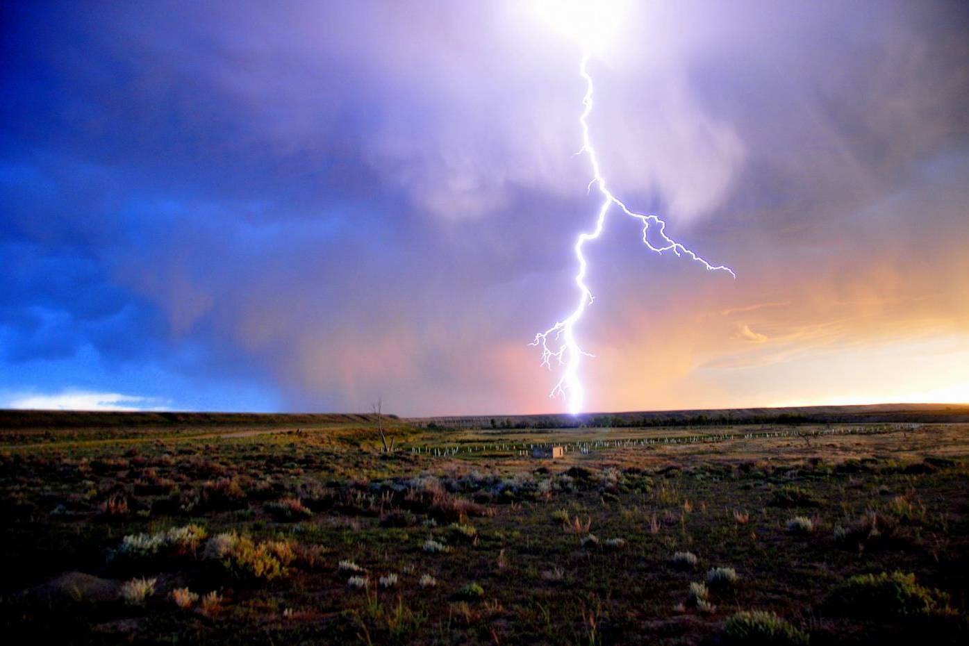Lightning striking an open plain under a storm sky