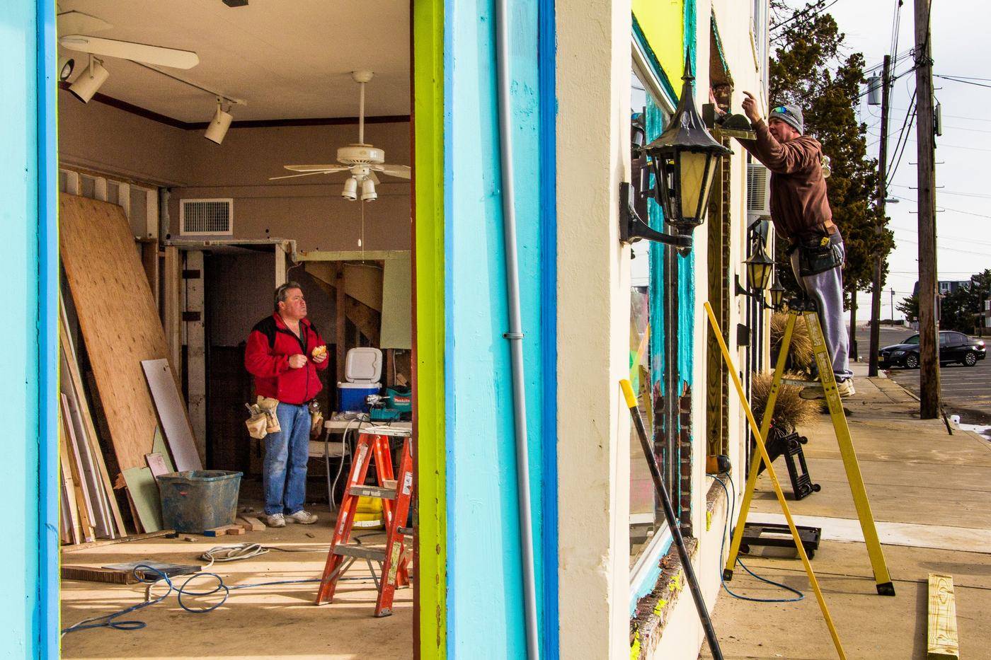 Workers rebuilding the inside of a storm-damaged shop